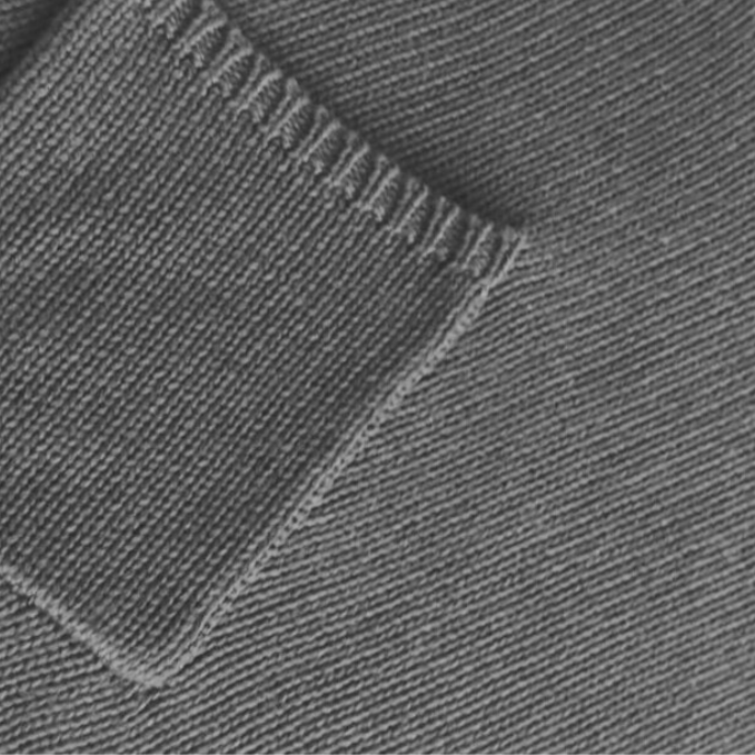 Close-up of gray knitted fabric texture with a focus on pocket detail.