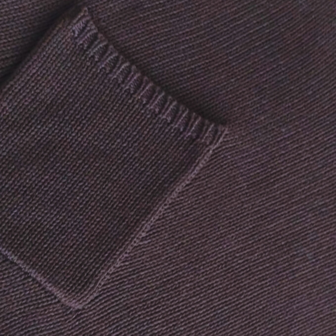 Close-up of a folded espresso brown knitted fabric with pocket detail